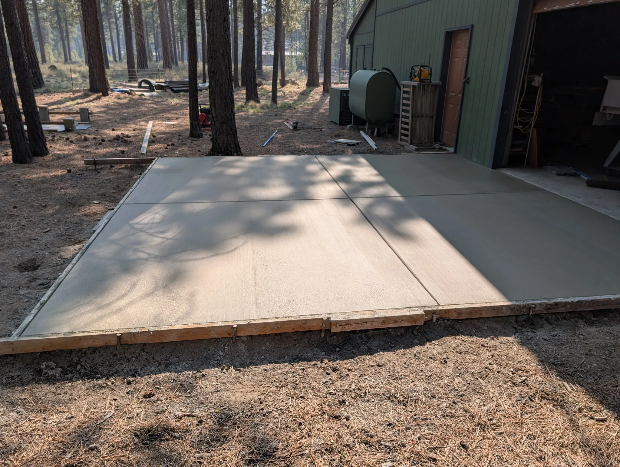 Concrete apron poured in front of a forested-property shop building